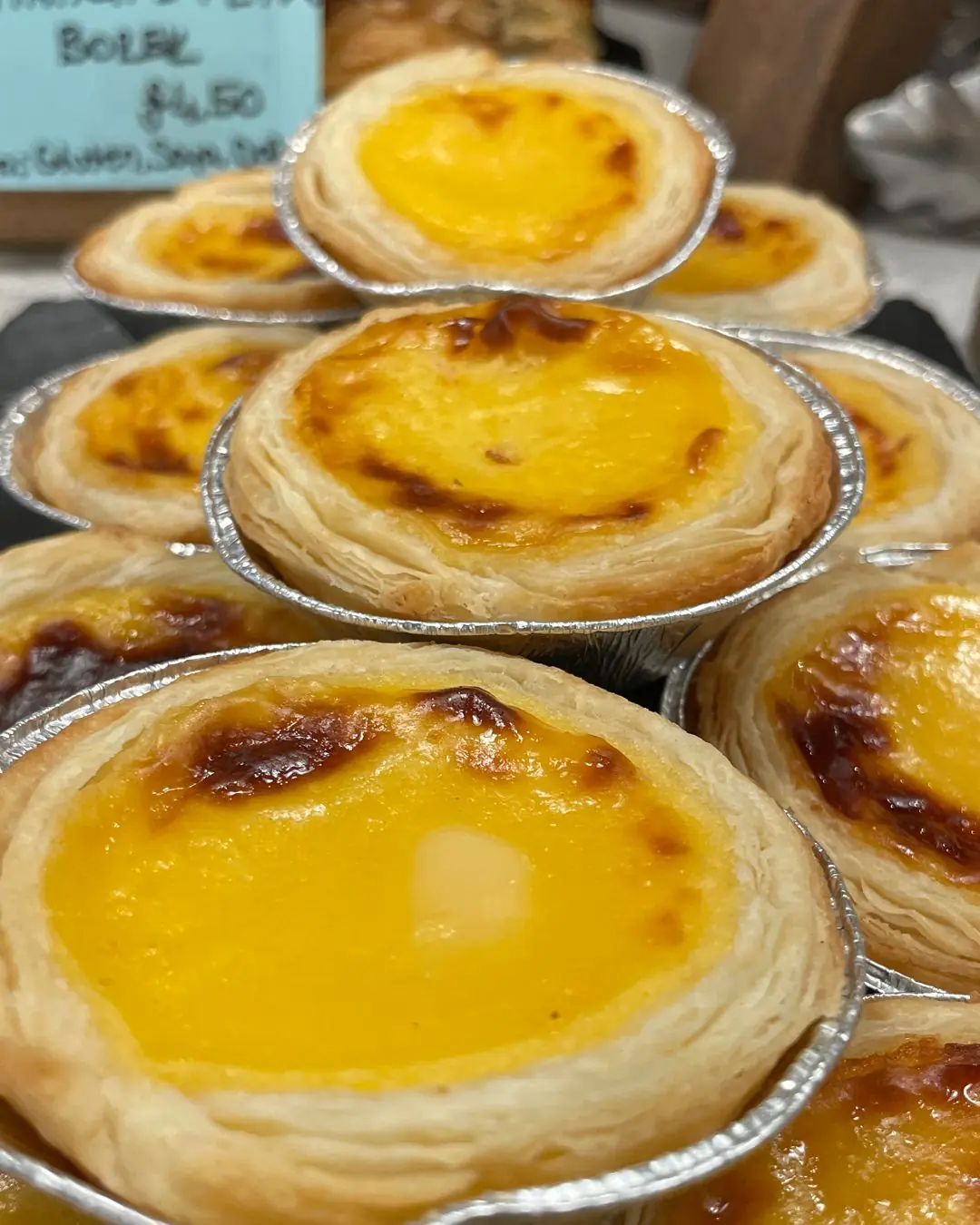 A freshly baked Pastel de Nata with a flaky crust and caramelised top.